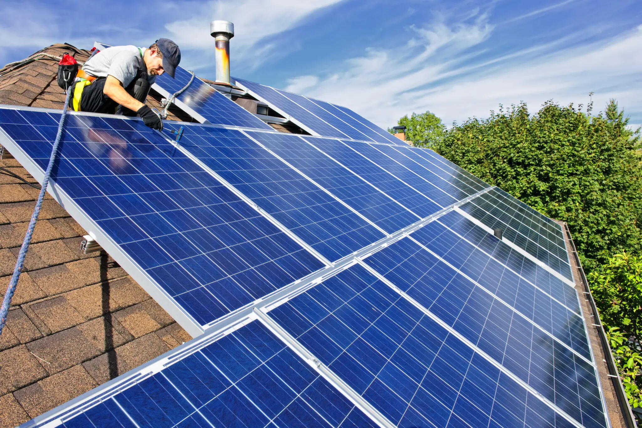 Worker installing solar panels on roof.