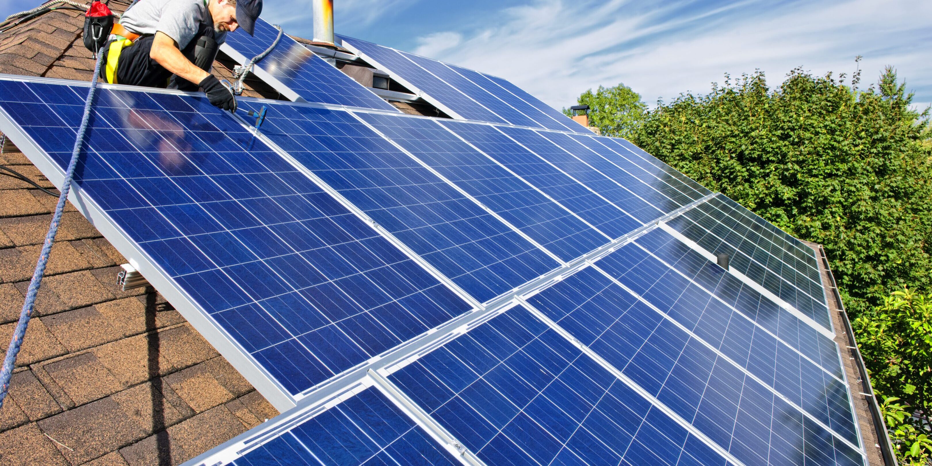 Worker installing solar panels on roof.