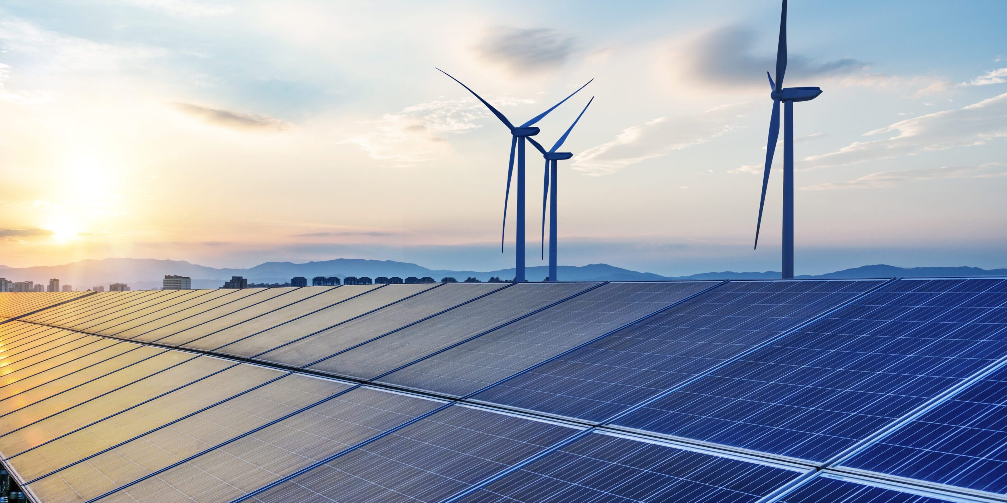 Solar panels and wind turbines at sunset.