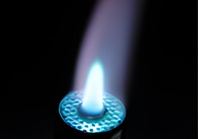 Blue flame from a lighter in darkness.